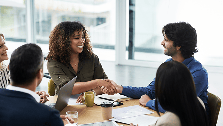 In a bright office, a team meets for a business meeting.