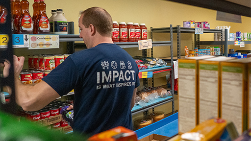 Elan volunteer stocks food shelf.