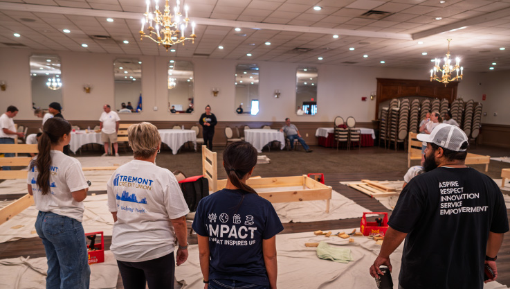 Volunteers look around at completed bed frames ready to be delivered.