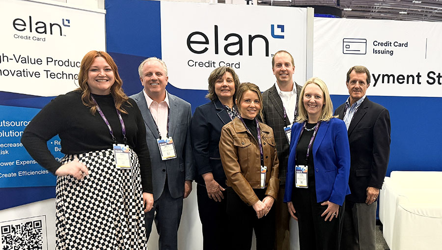 A group of Elan employees standing in front of the Elan conference booth